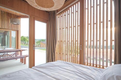 a bedroom with a bed and a large window at Szegzárd - the lodge in Szekszárd