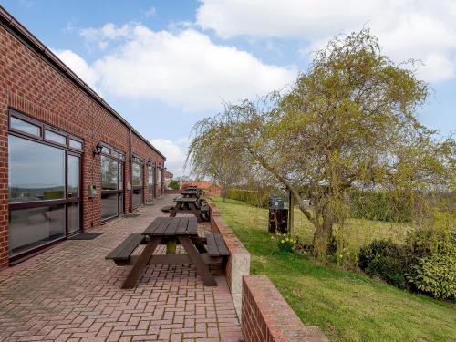 a row of picnic tables next to a brick building at Cottage 6 - Uk38217 in Ashby cum Fenby