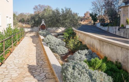 Un jardín con plantas blancas junto a un muro. en Lovely Apartment In Sveti Vid Miholjice, en Sveti Vid-Miholjice