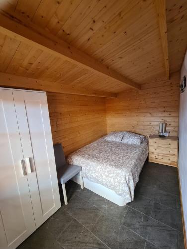 a bedroom with a bed and a chair in a room at La Casita de Madera in El Paso