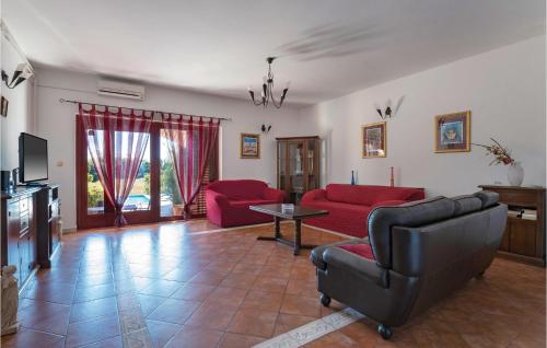 a living room with red couches and a tv at Holiday Home Krse Cr in Premantura