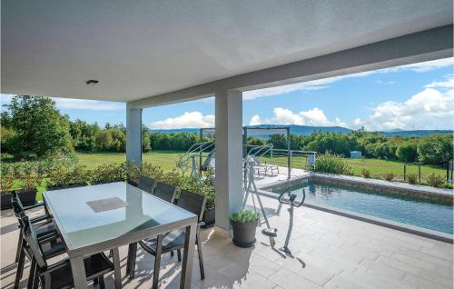 eine Terrasse mit Tisch und Stühlen und ein Swimmingpool in der Unterkunft Two-Bedroom Holiday Home In Barban in Barban