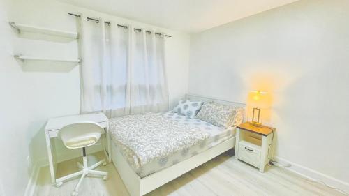 a small white bedroom with a bed and a desk at Amazing Home Near Toronto Airport with 2 Parking in Toronto
