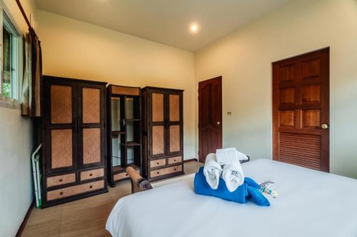 een slaapkamer met een bed met handdoeken erop bij Chaba Pool Villa in Nai Harn Beach