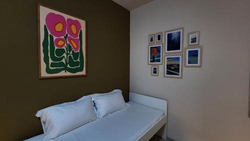 a white couch in a room with pictures on the wall at IHOC - Phuket OldTown in Ban Lo Long