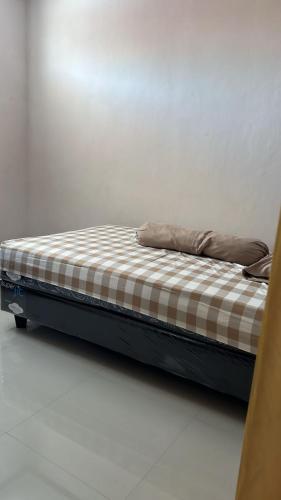 a bed with two pillows on it in a room at Kasuari Homestay by Ipoeng RB&B in Telaga