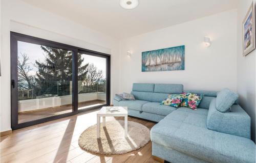 un salon avec un canapé bleu et une table dans l'établissement Stunning Home In Matulji, à Matulji