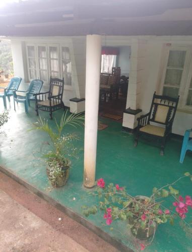 a porch of a house with chairs and flowers at Ohiya View Resort in Ohiya