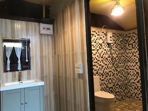 a bathroom with a shower with a toilet and a sink at บ้านต้นไม้แม่กำปอง Baan TONMAI MAEKAMPONG in Chiang Mai