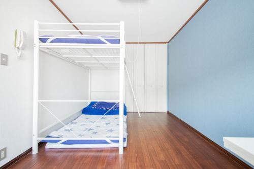 a white bunk bed in a room with a wooden floor at DOWNTOWN　TOKO11 in Asahikawa