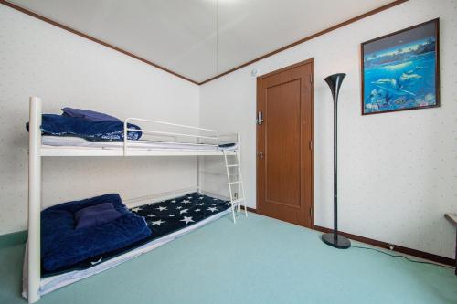 a room with two bunk beds and a door at DOWNTOWN　TOKO11 in Asahikawa