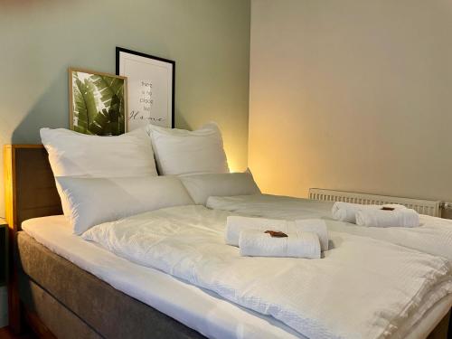 a large white bed with two towels on it at Cozy City Apartment im Zentrum in Nürnberg