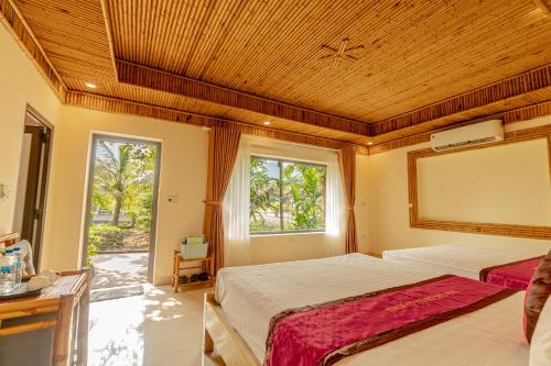 a large bedroom with two beds and a window at Tam Coc Green Garden Bungalow in Ninh Binh