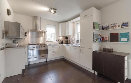 a kitchen with white cabinets and stainless steel appliances at Amazing Home In Wemeldinge With Wifi in Wemeldinge
