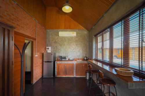 a kitchen with a refrigerator and some windows at The Wes Village, incl free Breakfast & free today's dish Thai food dinner in Chiang Dao