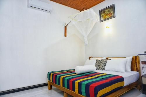 a bedroom with a bed with a colorful blanket at Sunrise Villa Pidurangala in Sigiriya