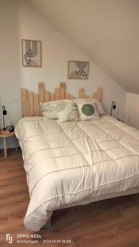 une chambre avec un grand lit avec des draps blancs dans l'établissement chalets du massif du Sancy, à Tauves