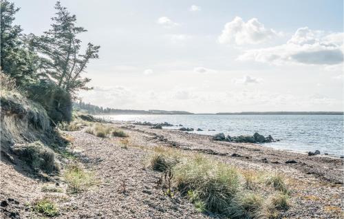 a rocky beach next to a body of water at Stunning Home In Spøttrup With Sauna in Vadum