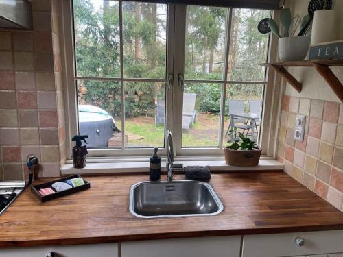 a kitchen counter with a sink and a window at Paulus aan de bos met hot tub in Epe