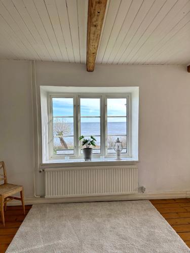 a room with a window with a view of the ocean at Strandnära hus Abbekås in Abbekås