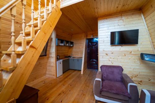 a living room with a staircase and a tv at Prime House Cottages in Keda