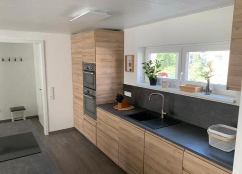 a kitchen with wooden cabinets and a sink and a window at Ferienwohnung König in Schnaittenbach
