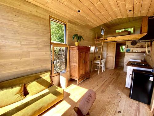 - un salon avec un canapé dans une cabane en rondins dans l'établissement Tiny à l'orée des bois, à Locquénolé