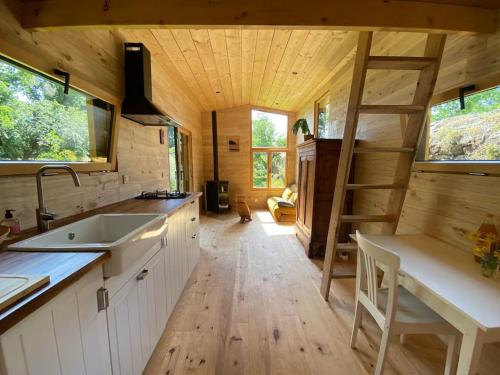 - une cuisine avec un évier et un escalier dans une petite maison dans l'établissement Tiny à l'orée des bois, à Locquénolé