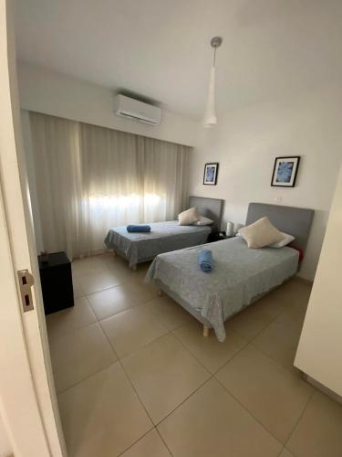 a bedroom with two beds and a tv in it at Elysia park wellness 2 bedroom apartment in Paphos