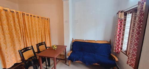 a bedroom with a bed and a table and chairs at Tranquil Meadows Hues in Kattappana