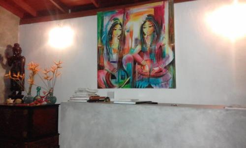 a large painting of two women on a wall at Secret Bay Hotel in Delgalla