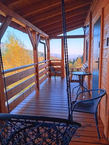 a porch with a hammock and a table and chairs at Sowi Stok in Sokolec