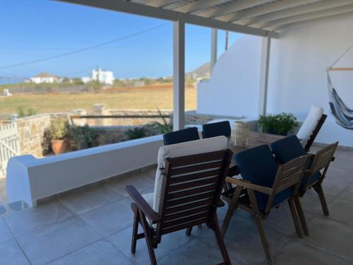 a patio with a table and chairs on a balcony at Villa Tranquilita in Kastraki Naxou