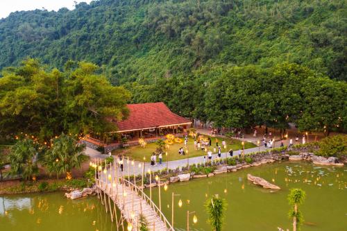 a group of people walking around a pond in a park at Thung Nham Resort in Ninh Binh