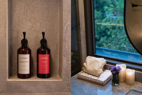 two bottles of wine sitting on a counter next to a window at The Lai Tiny House - Villa at Mae Kampong in Chiang Mai