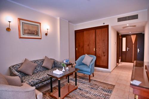 a living room with a couch and a chair at Swiss Inn Nile Hotel in Cairo