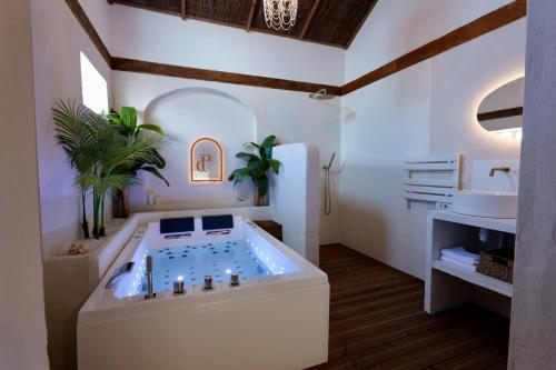 a bathroom with a jacuzzi tub and a sink at Love room Piccola casa, côté île in La Verpillière