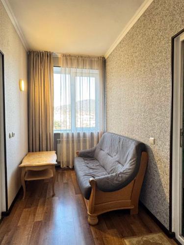 a living room with a couch and a window at Family Guest House in Bakuriani