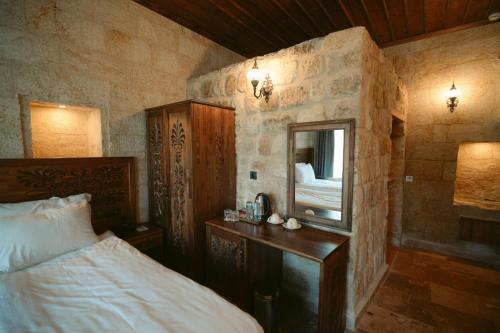 a bedroom with a bed and a mirror at Cappadocia Old Houses in Nevsehir