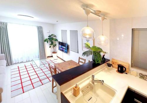 a kitchen with a sink and a living room at Naka HOUSE in Tokyo