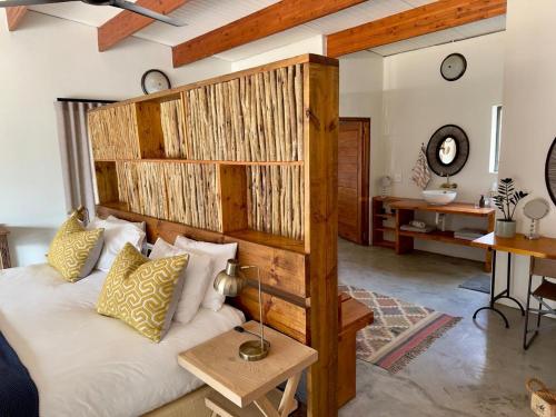 a bedroom with a bed with a wooden headboard at Mananga Bush Villa in Skukuza