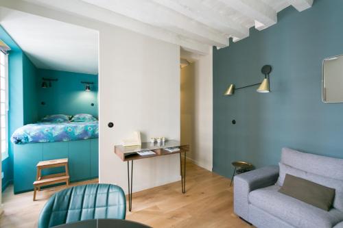 Cette chambre est dotée de murs bleus, d'un lit et d'un canapé. dans l'établissement Romantic Brand New Suite in Central Paris, Bathroom, Kitchen, à Paris