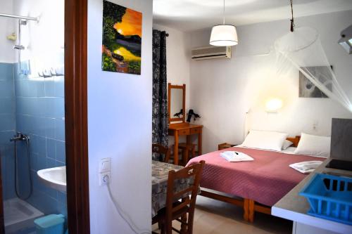 a small room with a bed and a bathroom at Kostas Apartments & studios in Agios Georgios Pagon