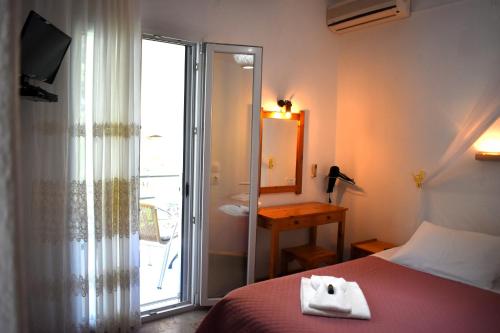 a hotel room with a bed and a sliding glass door at Kostas Apartments & studios in Agios Georgios Pagon