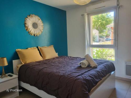 Cet appartement comprend une chambre dotée d'un lit avec un mur bleu et une fenêtre. dans l'établissement La Petite Cigale, grand balcon à 10min du Circuit Paul Richard et 15min de la mer - By AURAconciergerie, au Beausset