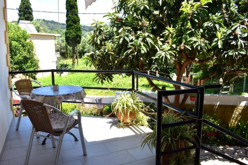 a balcony with a table and chairs and trees at Kostas Apartments & studios in Agios Georgios Pagon
