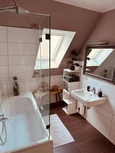 a bathroom with a bath tub and a sink at Lieblingsbude Schwerin in Schwerin