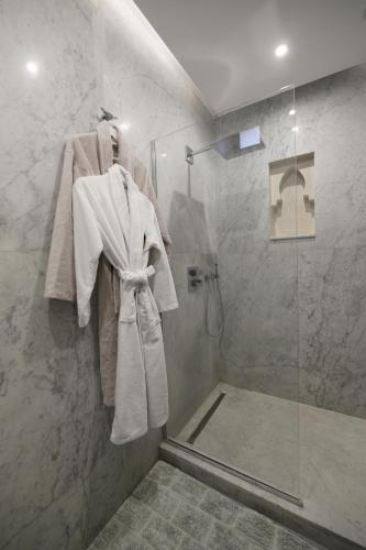 a bathroom with a shower with white towels on a wall at DAR KAYIS & LAILA in Marrakesh
