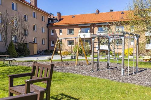 a playground with two swings in a park at Linnégatan 10 in Södertälje