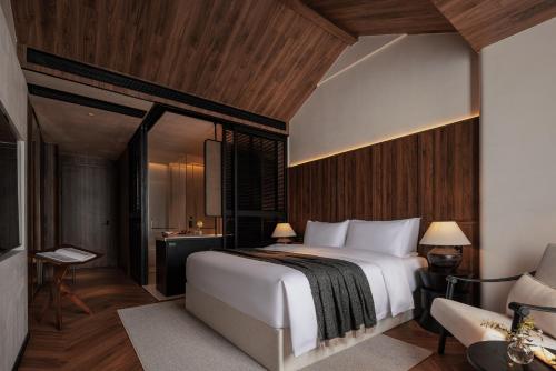 a bedroom with a large white bed and wooden walls at Rong Unique Hotel-Banyan Lake Scenery in Guilin